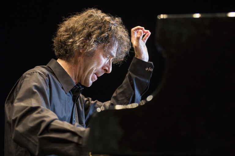 Ein Musiker spielt leidenschaftlich Klavier auf der Bühne.