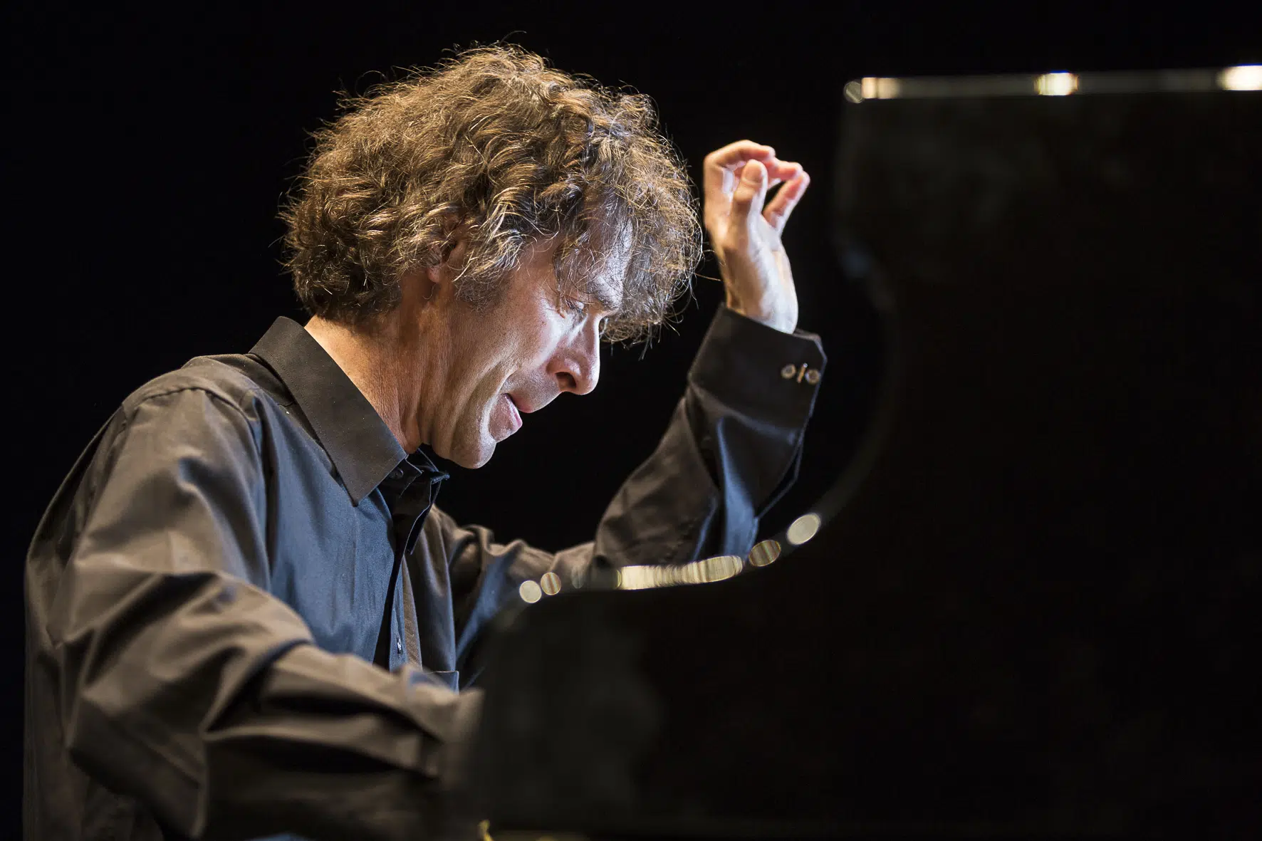 Ein Musiker spielt leidenschaftlich Klavier auf der Bühne.