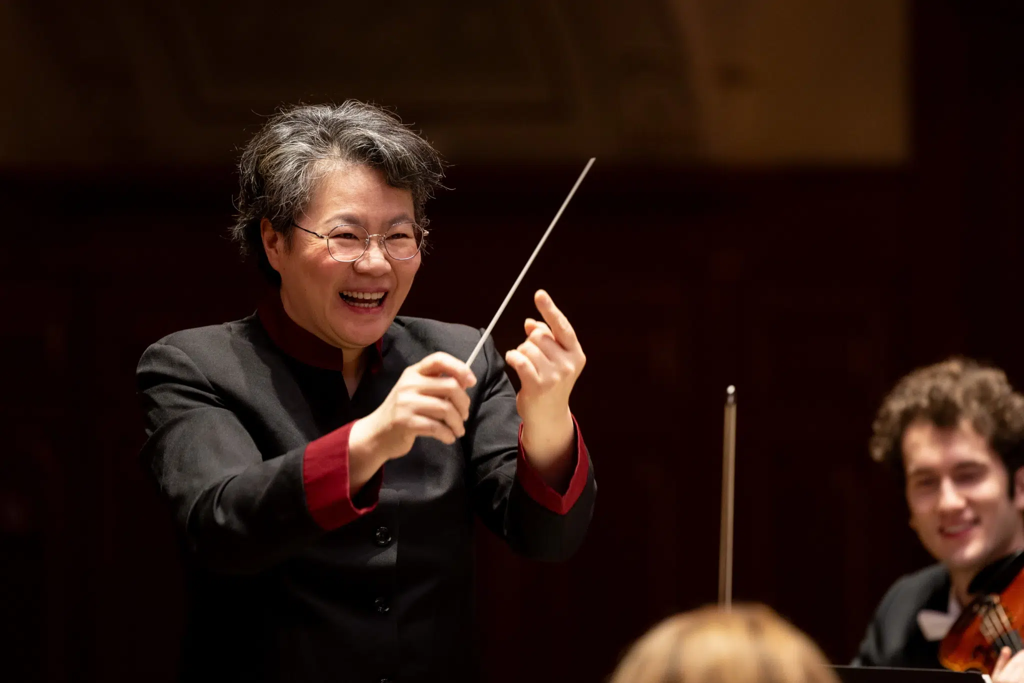 Orchesterdirigentin beim Proben mit einem Orchester