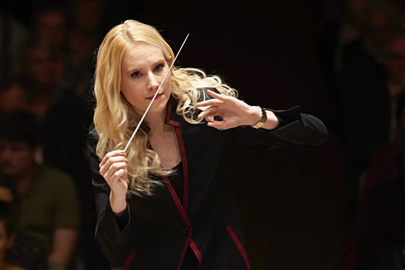 Dirigentin leitet ein Orchester mit einem Taktstock.